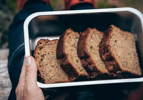 Skivor av saftig banankaka i en metallåda, perfekt för utflykten. Ett enkelt banankaka recept som passar alla.